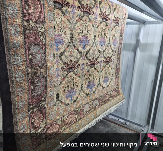 שטיח תלוי על מתקן מתכת לניקוי